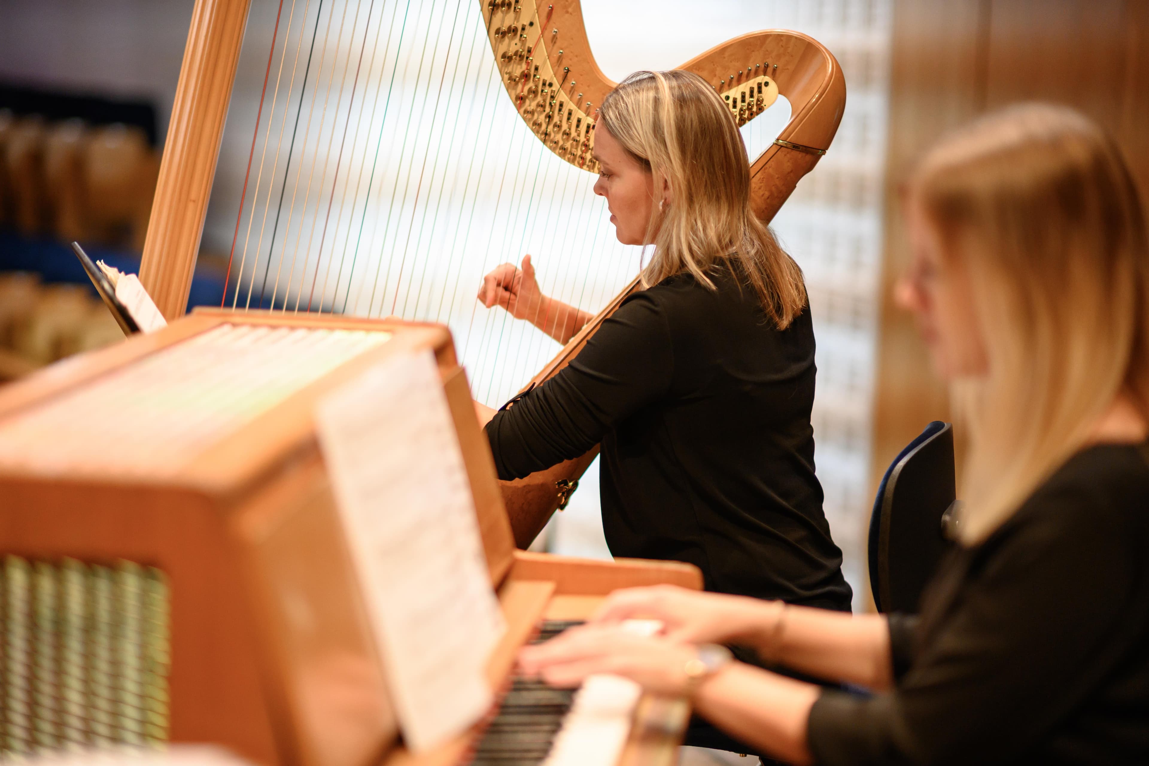 Harfe und Klavier mit Notenpult während einer Probe des 21st Century Orchestra