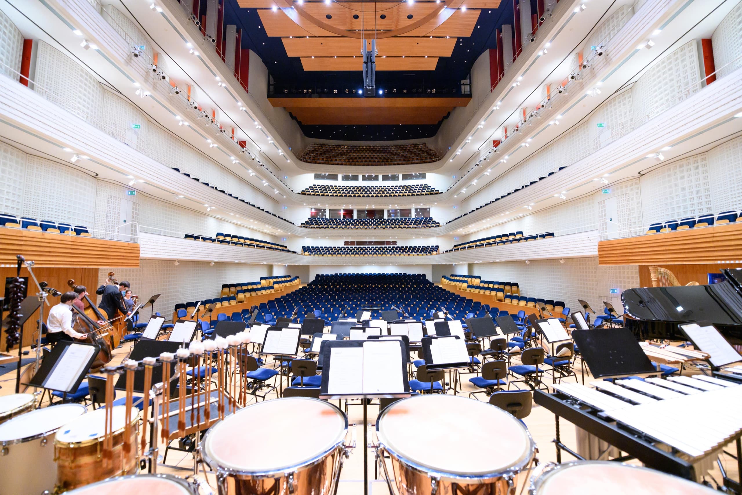 Die leere Bühne des KKL Luzern vor dem Konzert, Blick über Pauken und Notenpulte in den Saal